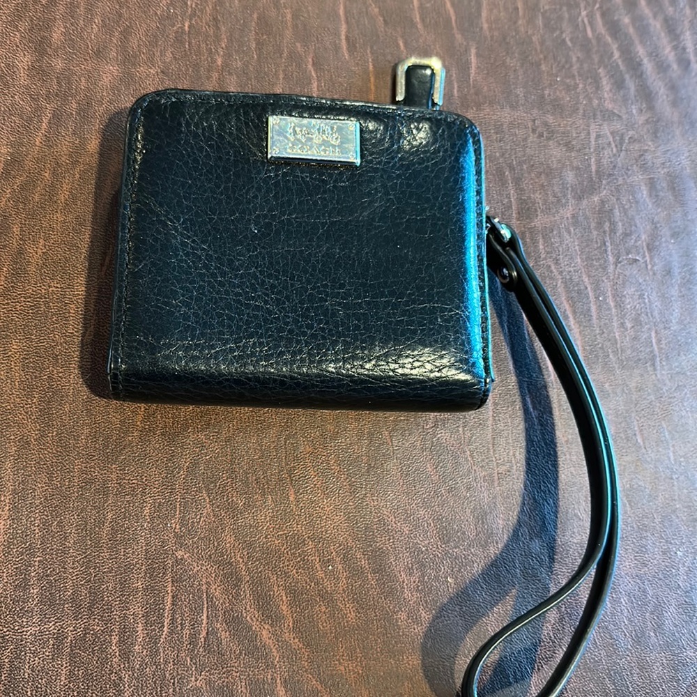 Small black Coach wallet with wristlet strap.